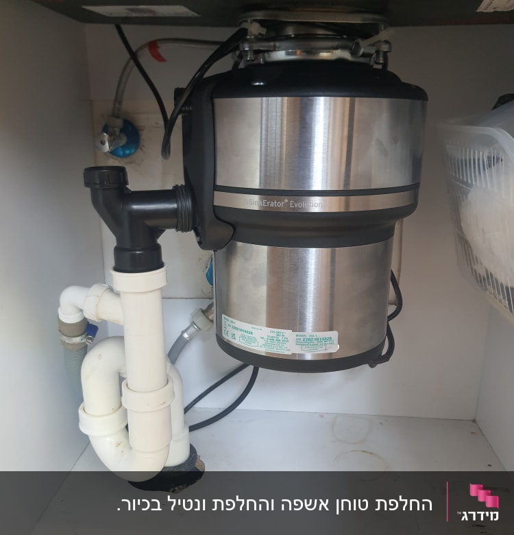 מטחנת אשפה מתחת לכיור עם צינורות פלסטיק